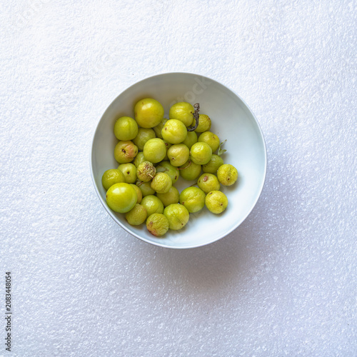 Small unripe green plums (Papaz plums) collected from a drying plum tree before reaching full maturity and photographed after losing their freshness.