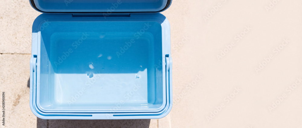 Obraz premium Empty blue cooler box open on hot day, keeping drinks cold, ready for picnic, beach, or travel