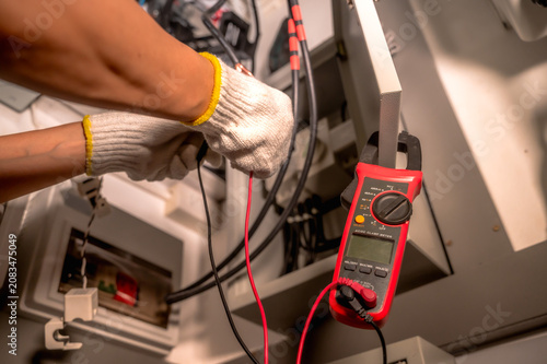 Close up unrecognized electrician in safety gloves upgrading home electric system for EV charging point