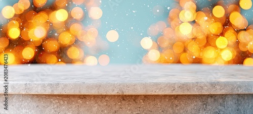 Empty stone countertop foreground with soft golden bokeh lights and tiny white speckles