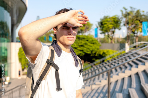 Man walking up the steps shields eyes from scorching sun