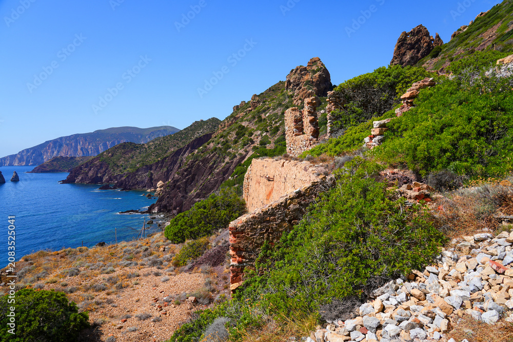 Fototapeta premium Historic ruins of the Laveria Lamarmora mining complex perched on the cliffs of Nebida overlooking the Mediterranean Sea, Sardinia, Italy