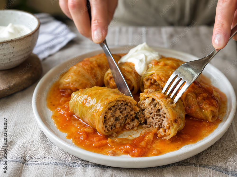 Φωτογραφία Plato de rollos de repollo rellenos de carne y arroz con salsa roja en una mesa