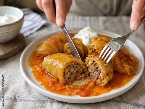 Foto Plato de rollos de repollo rellenos de carne y arroz con salsa roja en una mesa