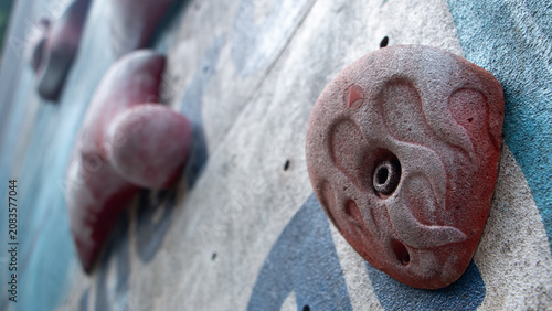 Tableau sur toile Low angle shot of colorful climbing holds fixed on an indoor climbing wall, showcasing unique textures and perspective for bouldering and sport climbing