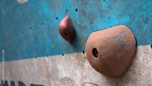 Photos Low angle shot of colorful climbing holds fixed on an indoor climbing wall, showcasing unique textures and perspective for bouldering and sport climbing