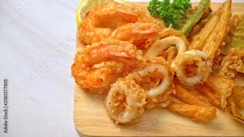 Fried chicken with noodles and vegetables on a wooden board
