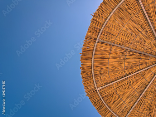 Bottom View of a Straw Beach Umbrella Against Blue Sky