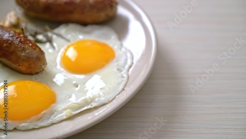 Fried eggs with sausage on a pink plate in a bright kitchen