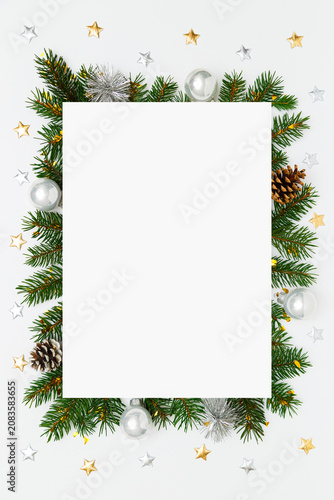 Christmas, New Year vertical frame of fir tree branches, Christmas baubles, decorations on white flat lay background. Perfect for holiday greetings, banners, social media. Copy space