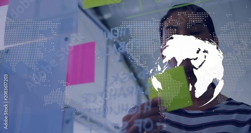 Globe overlay appearing, rotating on glass, woman writing, placing sticky notes for business plan