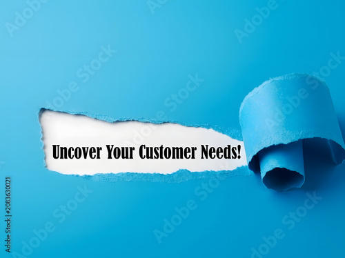 Uncover Your Customer Needs Message Revealed Through Torn Paper On bright blue Background For Marketing Research And Business Strategy Concept