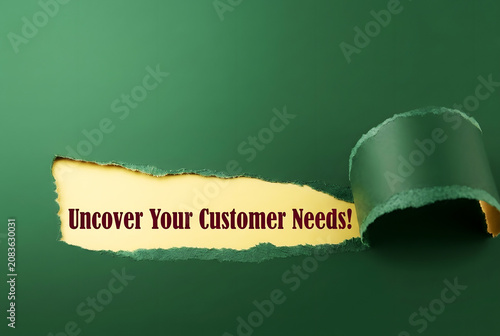 Uncover Your Customer Needs Message Revealed Through Torn Paper On dark green Background For Marketing Research And Business Strategy Concept