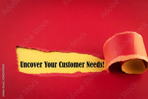 Uncover Your Customer Needs Message Revealed Through Torn Paper On deep red Background For Marketing Research And Business Strategy Concept