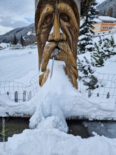 Geschnitzter Brunnen vereist