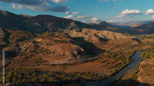 Distant passenger train moves along a riverbank (Dogu Ekspresi)