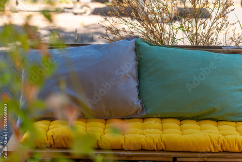 Cushions on a bench in an outdoor setting during a sunny day