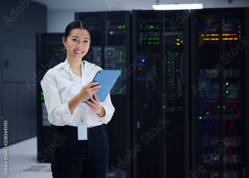 Female Technology Specialist Standing in Server Room