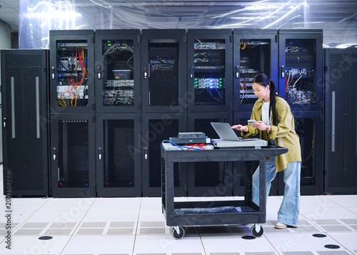 Asian Female Engineer Working in Modern Data Center