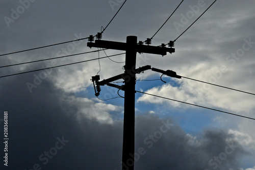 фотографія Silhouette of retrofitted old power pole with dropout fuses