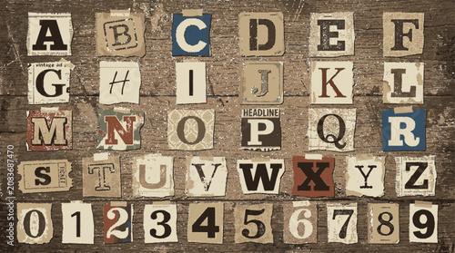 Vintage ransom note alphabet and numbers collection on textured rustic wood surface