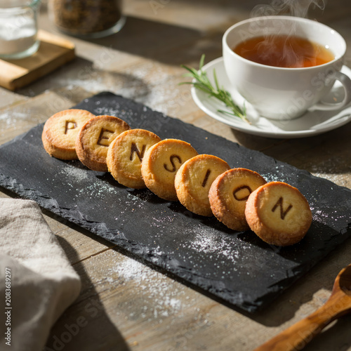 Pension Word Spelled on Letter Cookies with Hot Tea for Retirement Concept