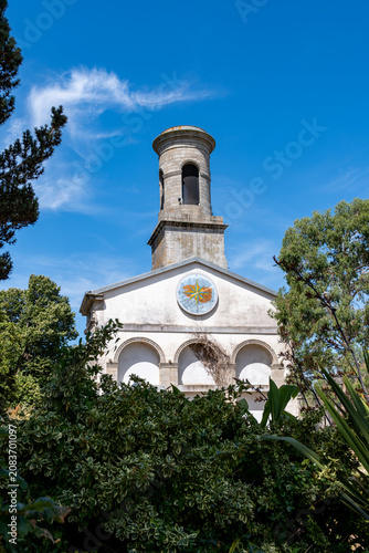 Church Eglise Saint Guenole is seen among green plants and trees