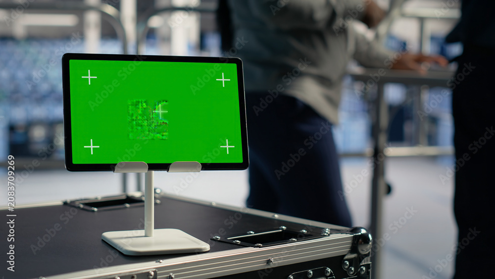 Obraz premium Software developer uses a green screen tablet to manage AI systems, machine learning workflows and server performance.