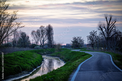 Foto Winding country road and canal at sunset in Emilia-Romagna