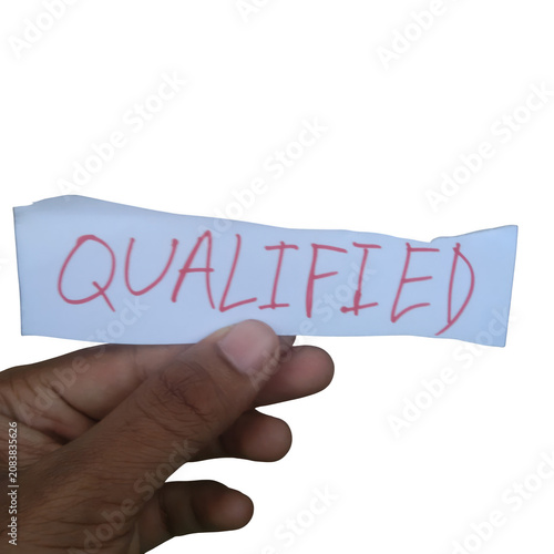 Fotografie Hand holding a paper sign with the word qualified isolated on transparent backgr