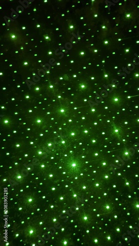 Numerous brilliant green laser points illuminating a deep dark surface