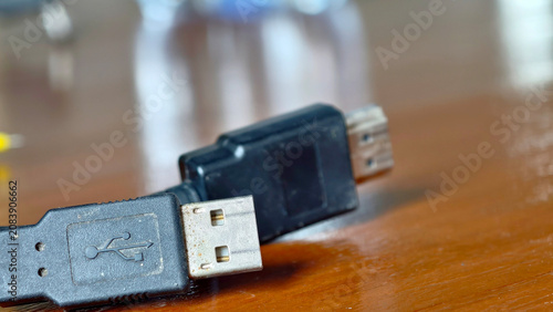 Close-up of a USB cable connector on a wooden surface.