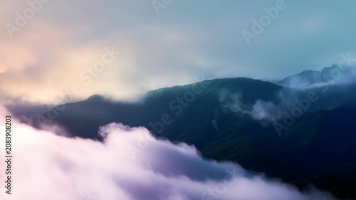 Dreamy pastel mist envelops distant mountain peaks under a soft, ethereal sky, creating a tranquil and serene landscape. Gentle gradients of purple and pink hues evoke a peaceful, calming mood