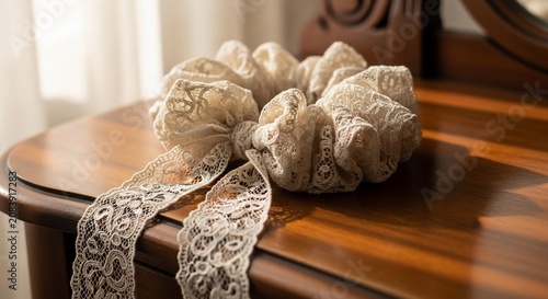 Elegant White Lace Hair Scrunchie Accessory Resting on a Polished Wooden Table with Soft Lighting