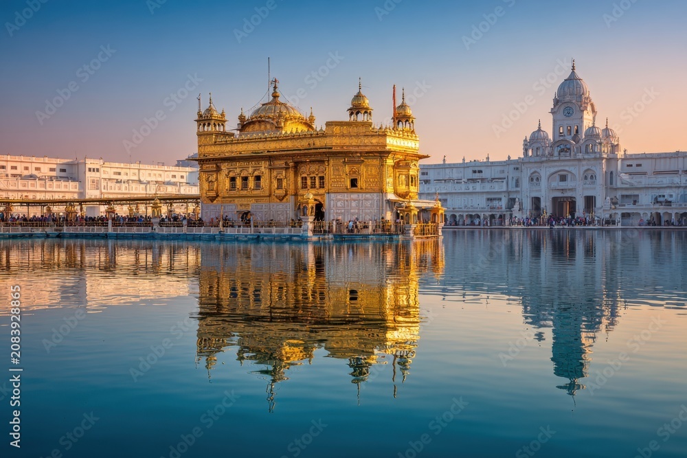 Fototapeta premium Golden Temple Harmandir Sahib seen in sacred pool with reflection and surroundings before sunset in Amritsar, Punjab