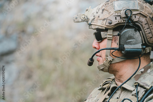 Outdoor military concept. Military soldier in profile wearing helmet headset and sunglasses