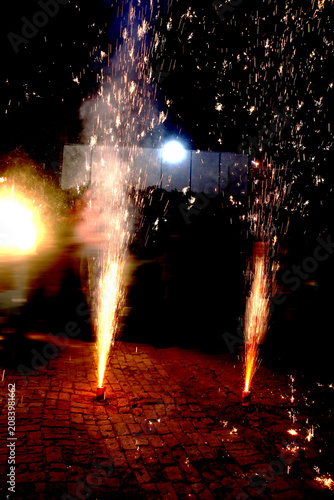 Ground Firework Fountains – Twin Orange Yellow Sparks with Glowing Trails and Smoke Illuminated Against Dark Festive Night Celebration Concept