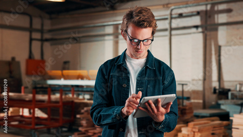 Obraz na plátne Carpentry, happy and man on tablet in workshop for planning, schedule or manufacturing quote