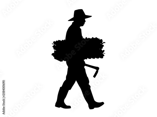 Silhouette of a Farmer Carrying a Bundle of Plants and a Hoe