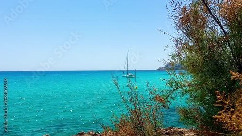 Crystal clear turquoise sea water and scenic rocky coast with sailing boats under a blue sky. summer vacation concept.
