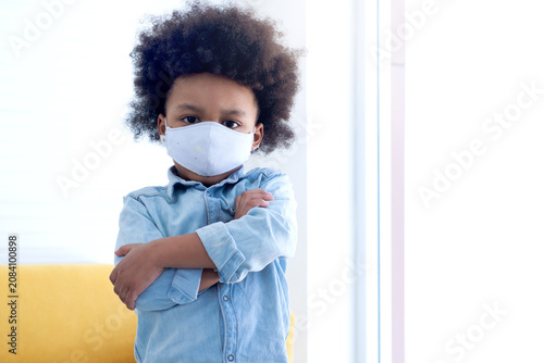 African boy wears a face mask for hygiene purposes. Prevention of respiratory infectious diseases in children. looking at camera