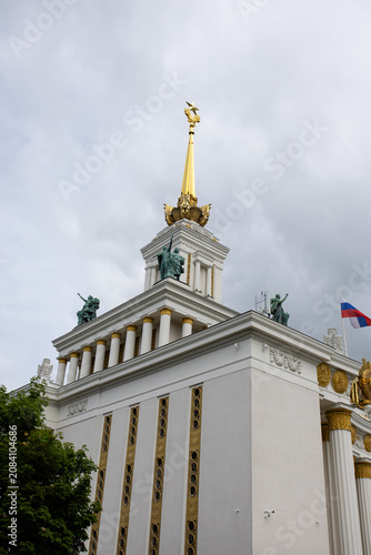 The golden spire with a star and sculptures on Pavilion No. 1 (Central) at VDNKh in Moscow. This monumental building is in the Stalinist Empire style, or Socialist Classicism.