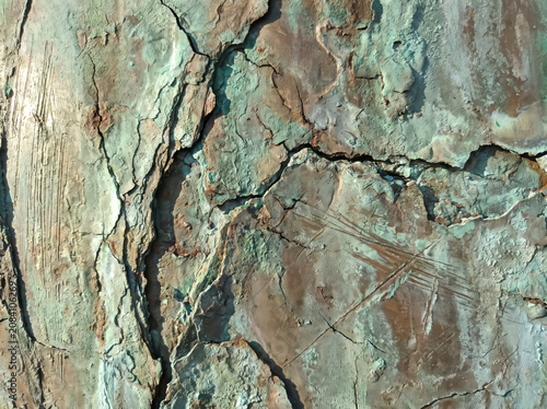 Weathered Surface with Deep Cracks and Green Patina.