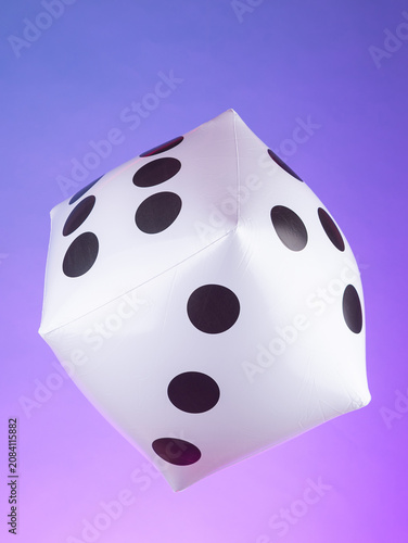 Close-up of an inflatable toy shaped like a gaming cube against a purple background. Playful and colorful decoration