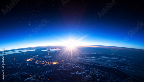 Sunrise over earth atmosphere horizon, starburst sun ray light, digital pixelated city lights, deep space blue sky background