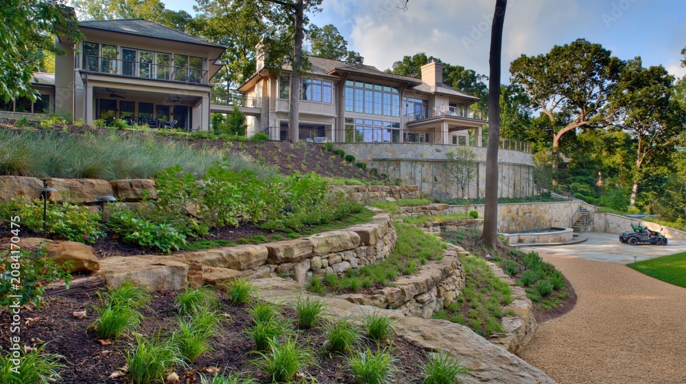 Fototapeta premium Contemporary estate with curved stone terraces and planted slopes