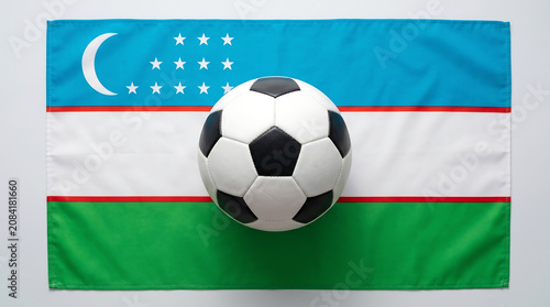 Soccer ball placed in the center of Uzbekistan national flag top view