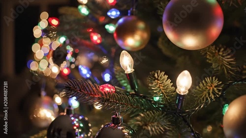 Lit Christmas tree with multi-colored lights and baubles.