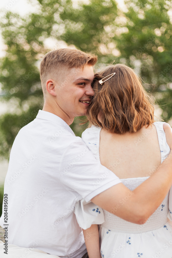 Fototapeta premium Young couple embracing outdoors with a warm smile and gentle touch