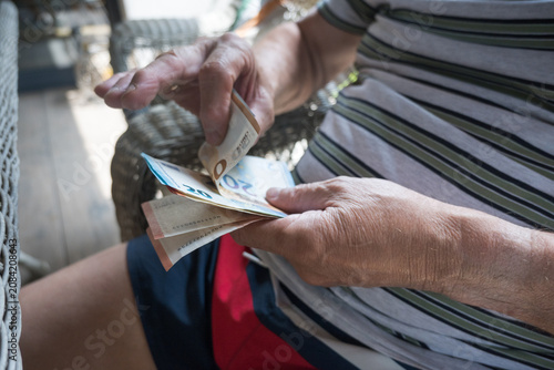 Konstfotografi A pensioner is counting euro banknotes.